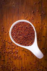 Red Quinoa in White Scoop on Wooden Tabletop