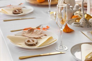 Festive table setting with autumn leaf and golden cutlery for Halloween party
