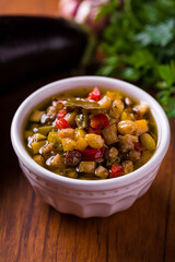 Colorful Caponata Vegetable Medley in a White Ceramic Bowl on Wooden Table