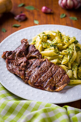 Grilled Steak Served with Pesto Penne Pasta on Elegant Plate