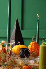 Festive table setting with pumpkins and cauldron for Halloween party, closeup