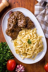 Delicious Tagliatelle Pasta With Steak and Mushroom Sauce On Wooden Table