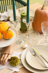 Festive table setting with burning candles and pumpkins for Halloween party