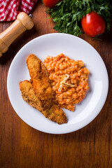 Delicious Breaded Fish Fillet with Tomato Risotto on Wooden Table