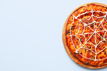 Wooden board with tasty pizza for Halloween party on blue background