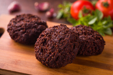 Delicious Crispy Meatball With Fresh Herbs and Tomatoes on Wooden Board
