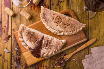Delicious Chocolate Empanadas with Wine on Rustic Wooden Table
