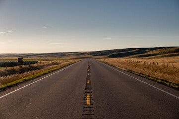 Fototapeta premium Sunrise highway in the badlands of Southern Alberta.