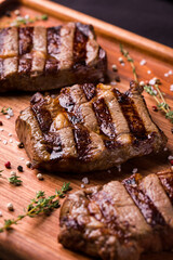 Delicious Grilled Ancho Steaks on Wooden Platter with Seasoning