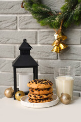 Christmas cookies with milk and lantern on stool in room, closeup