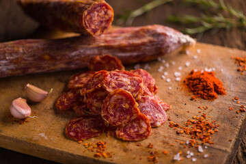 Sliced Salami with Garlic and Spices on Rustic Wooden Board