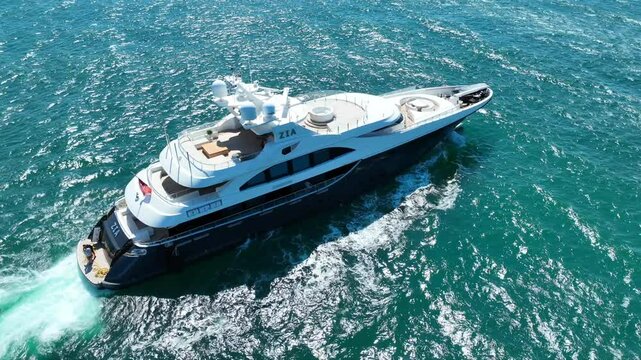Aerial drone video of beautiful modern small yacht cruising in low speed in Aegean deep blue sea