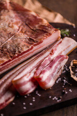 Close-Up of Raw Bacon Slices on Wooden Cutting Board