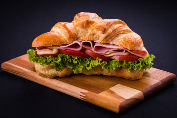 Delicious Croissant Sandwich With Ham Cheese and Fresh Lettuce