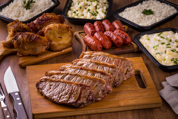 Grilled Meat With Sides and Sausages on Rustic Wooden Table