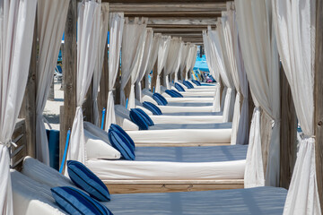 Row of cabanas with beds and pillows at a beach luxury resort.
