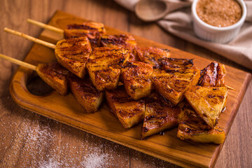 Grilled Pineapple Skewers on Wooden Cutting Board with Sugar