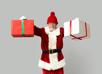 Cool Santa Claus with gift boxes on grey background