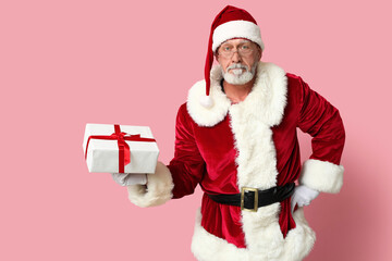 Cool Santa Claus with gift box on pink background