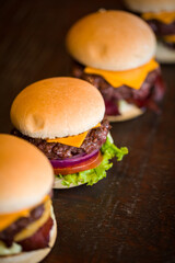 Delicious Cheeseburgers on A Wooden Table Top with Fresh Ingredients