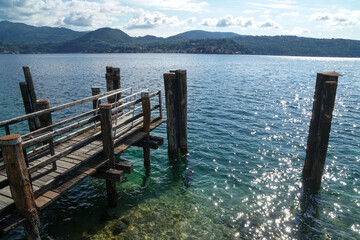 Scenery of boats and pier in a sunny on D'Orta lake, Italy
