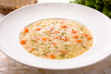 Warm Bowl Of Vegetable And Rice Canja Soup On A White Plate