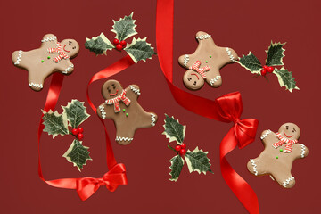 Sweet gingerbread cookies with Christmas decor on red background.