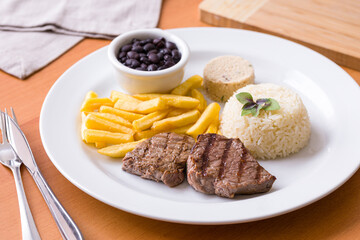 Delicious Brazilian Steak Lunch with Rice and Fries Served