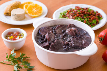 Delicious Traditional Brazilian Feijoada with Side Dishes on Table