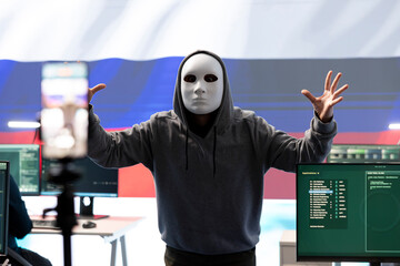 Anonymous hacker expert in a russian hacking high tech office, digital threats and political...