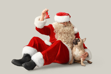 Santa Claus with French bulldog and Christmas bell on grey background