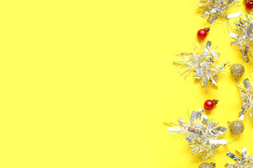 Composition with tinsel and Christmas balls on yellow background