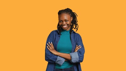 Cheerful teenager having positive wellbeing, feeling optimistic, isolated over studio background....