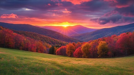 Stunning sunrise illuminates rolling hills adorned with vibrant autumn leaves and striking mountain silhouettes beneath a cloudy sky