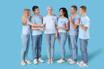 Mature woman after chemotherapy and people with lavender awareness ribbons on blue background. World Cancer Day