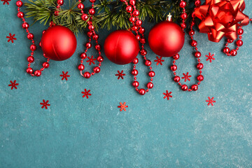 Beautiful composition with Christmas balls, fir branches and red beads garland on blue background