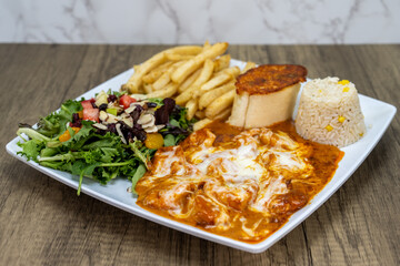 Delicious looking shrimp dish smothered in cheese served with rice and french fries for an excellent Mexican seafood meal
