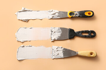 Knives with white putty on beige background