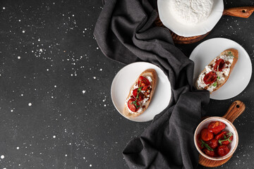 Plates of tasty tomato bruschetta with ricotta on black background