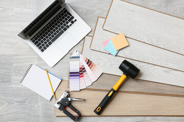 Tools, laptop, color palettes and laminate boards on floor