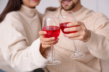Young couple with glasses of wine at home on autumn day, closeup