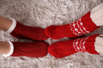Young couple in warm socks at home on autumn day, top view