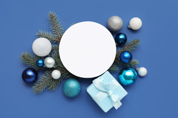 Blank card, Christmas balls, gift box and fir branches on blue background