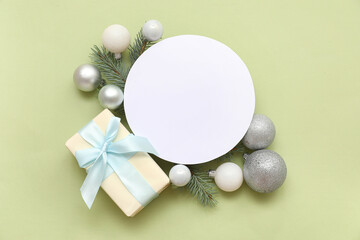 Blank card, Christmas balls and gift box on green background