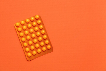Blister pack with pills on orange background