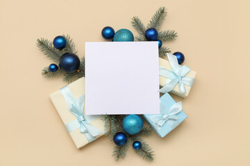 Blank card, Christmas balls and gift boxes on beige background