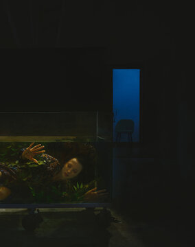 Ethereal underwater portrait of a woman in a dark tank