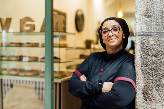 Proud owner smiling in her vegan bakery store