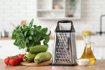Grater and vegetables on table in kitchen