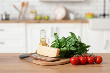 Grater, cheese, tomatoes and oil on table in kitchen
